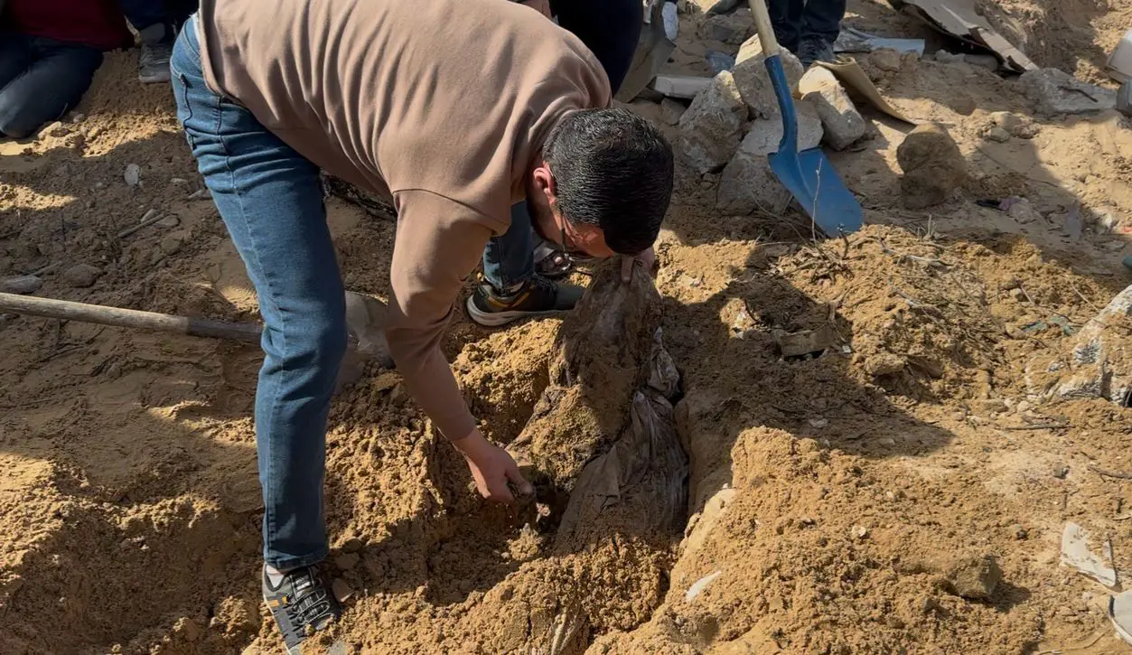 شخص يستخرج جثة من قبر