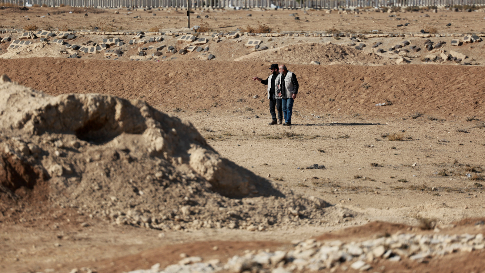 أشخاص يتفقدون موقع مقبرة جماعية 