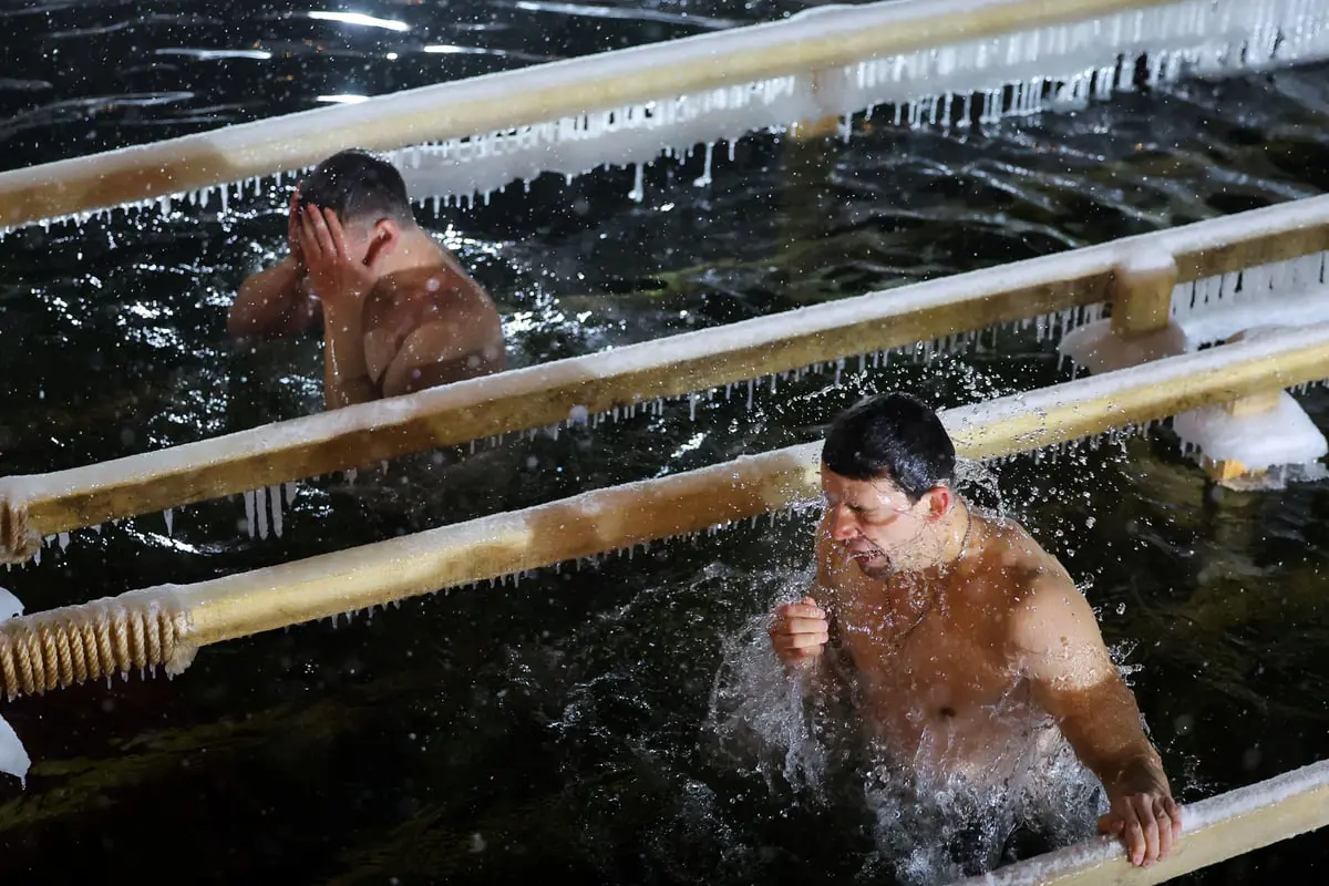 الروس يسبحون بالمياه المتجمدة احتفالا بعيد الغطاس (صور)