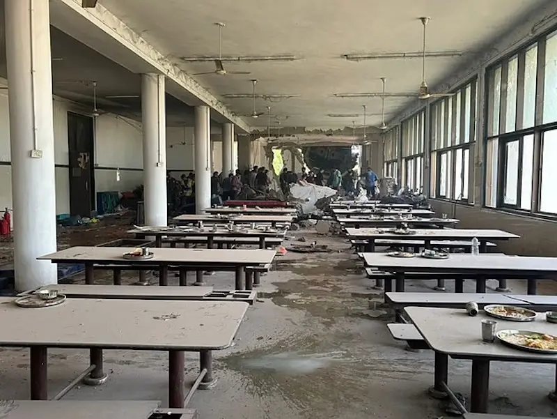 مدنيون يتفقدون المصابين في مقصف الكلية الذي اصطدمت به الطائرة