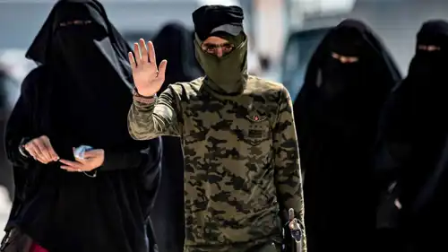 نساء يظهرن خلف رجل ينتمي لتنظيم داعش
