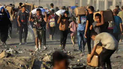 فلسطينيون يحملون إمدادات الإغاثة في بيت لاهيا