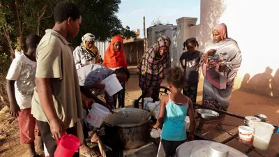 لاجئون سودانيون ينتظرون حصتهم من الطعام