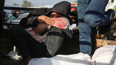 شخص يحمل جثة طفل قضى جراء القصف الإسرائيلي على غزة