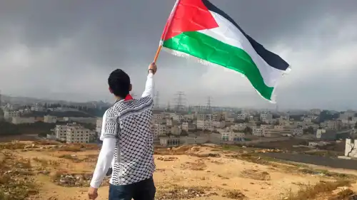 شاب فلسطيني يحمل علم بلاده