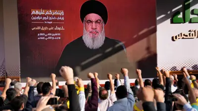 لبنانيون يرددون شعارات أمام صورة حسن نصرالله
