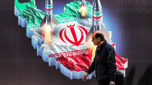 شخص يمر أمام لافتة في طهران