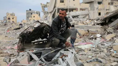 فلسطيني من غزة يجلس على أنقاض الدمار