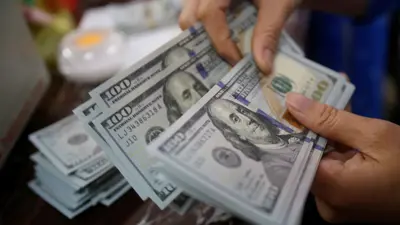 شخص يعد أوراق الدولار الأمريكي