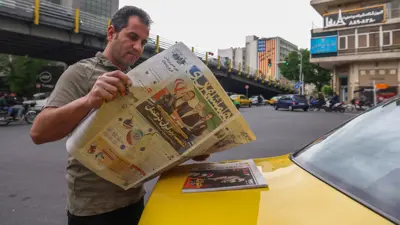 إيراني يتابع أخبار المفاوضات في الصحف الورقية