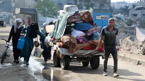 فلسطينيون يفرون مع أمتعتهم من حي أبو إسكندر شمال مدينة غزة