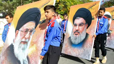 صورتا نصر الله وخامنئي خلال مناسبة لميليشيا حزب الله