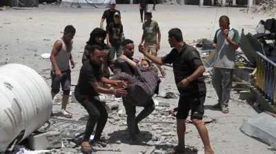 فلسطينيون يحملون فتاة جريحة إثر القصف الإسرائيلي