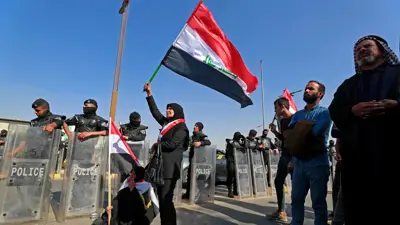 عراقية ترفع علم بلادها خلال احتجاجات سابقة
