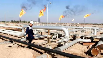 عامل يسير في حقل نهر بن عمر النفطي، شمال البصرة، العراق