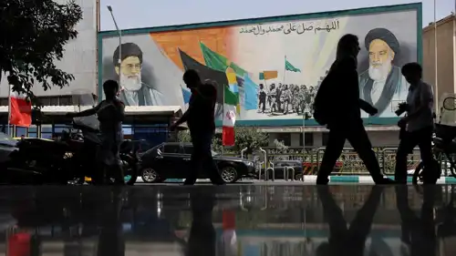 إيرانيون يمرون أمام لافتة لخامنئي في طهران