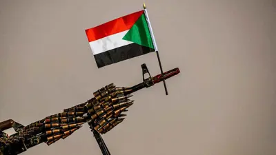 قطعة سلاح مرفوعا عليها علم السودان