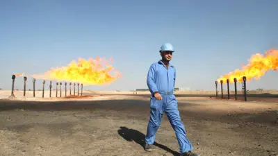 مهندس في حقل نفطي عراقي يشعل بعض الغاز المستخرج مع النفط الخام لنقص المنشآت اللازمة لمعالجته