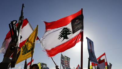 العلم اللبناني يتوسطه صورة لحسن نصرالله