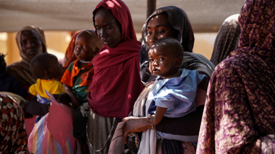 سودانية تحمل طفلها