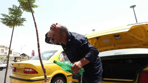 سائق سيارة أجرة يرش الماء على نفسه في طهران