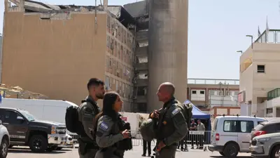 عناصر أمن إسرائيليون بجوار مبنى متضرر