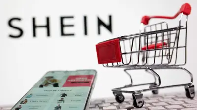 لوحة مفاتيح وعربة تسوق أمام شعار شي إن